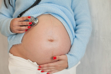 孕妇在腹部听诊器听婴儿