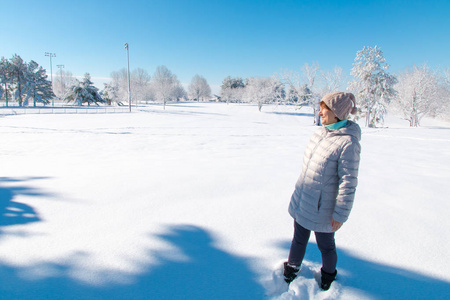 冬天公园里的女人享受阳光明媚的天气。