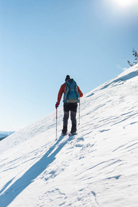 穿雪鞋的登山者背着一个背包。 冬天在山上旅行。 大自然中的极端假期。