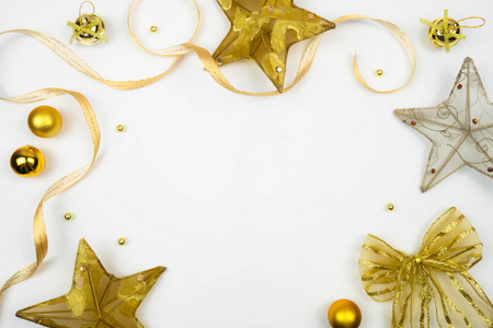创意圣诞版面。 金色的星星丝带和白色背景上的球，复制空间。 边境安排。 平躺顶部视图。