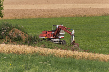 德国南部乡村靠近慕尼黑和斯图加特市的一个玉米地乡村景观上有茅屋和泥土的挖掘机