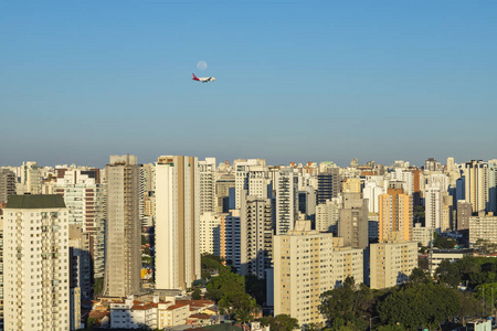 美丽的风景在城市，飞机和月亮在阳光明媚的日子。巴西圣保罗市。