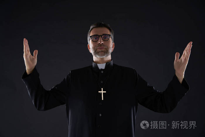 牧师张开双臂祝福祈祷上帝的手势隔离在黑色