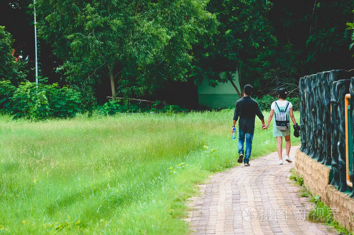 在浪漫的夏日,两对快乐的年轻情侣在绿色的秋天公园散步.