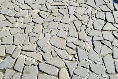 石路的质地, 人行道, 大灰色的旧中世纪圆形强石, 鹅卵石的墙壁。的背景