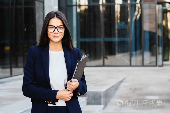 年轻成功女商人戴眼镜和寻找相机职业女经理在公司西装.