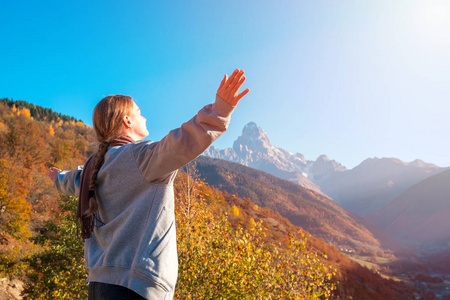 美丽的女孩举起手臂到斯瓦内蒂山乌什巴山放松，同时旅行。