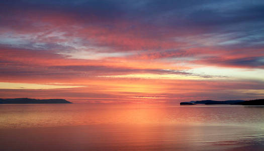 日落时海湾。 海上明亮的日出景观。 清晨的火红。 湖面上黎明寂静。