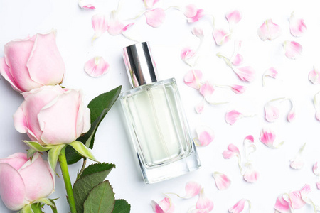 漂亮的香水瓶和白色背景的玫瑰