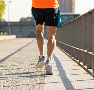 在城市训练中，用复制空间关闭运动健腿与撕裂小腿肌肉的形象，锻炼马拉松和健康的生活方式概念。