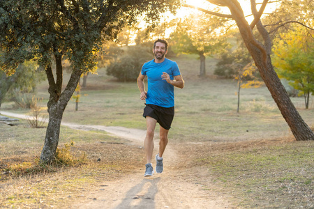 在美丽的夏日日落公园外的马拉松运动服装跑步训练中的快乐跑步者，在运动健康的生活方式和慢跑越野训练户外概念。