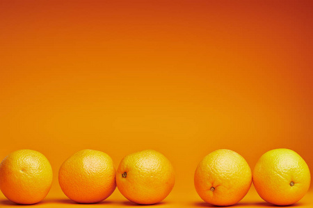 在橙色背景下近距离观看新鲜成熟的橘子