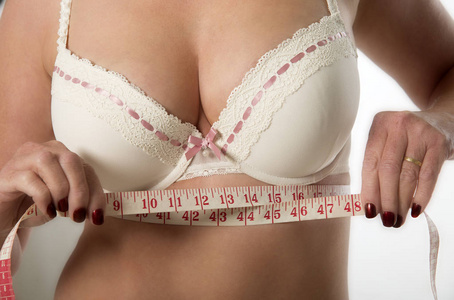 中年妇女用卷尺在胸罩测量下检查。 2014年8月