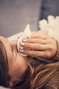 患有季节性感染流感过敏症的患病妇女躺在床上。