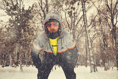 人们在下雪的公园慢跑和寒冷的天气后停下来。