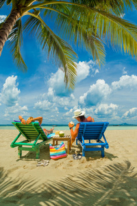一对夫妇坐在泰国热带海滩上放松的浪漫场景