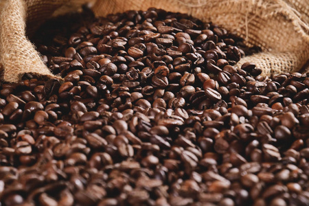 木制背景上的咖啡纹理的顶部视图。新鲜优质优质咖啡豆仍然是热的和蒸的