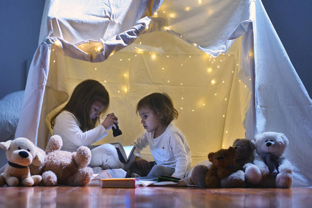 两个小女孩晚上在家玩，搭建一个露营帐篷，用手电筒看书，睡在里面。 游戏魔术创意报警系统