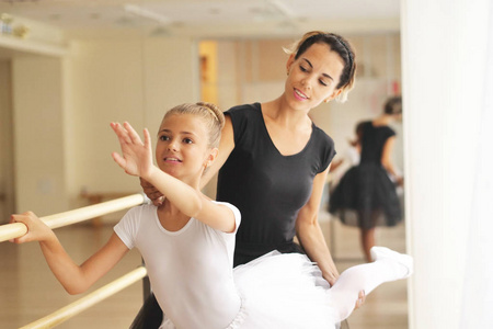 一位古典舞蹈老师教他的年轻学生一些步骤，他们想学习如何跳舞。 抱负教育教学与热爱舞蹈