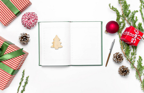 打开笔记本，空白页，礼品盒，杉树枝在白色背景平躺顶部视图。圣诞节规划概念假日装饰2019年目标。新年，圣诞节，冬季装饰