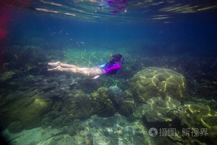 女人在水下游泳美丽的女人在水下潜水之前到珊瑚礁女人浮潜在蓝色面具