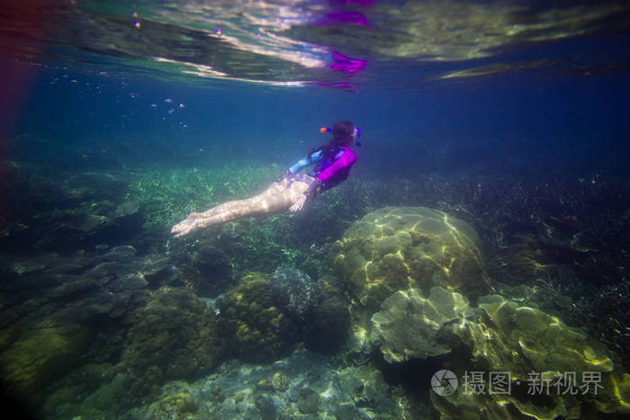 女人在水下游泳美丽的女人在水下潜水之前到珊瑚礁女人浮潜在蓝色面具