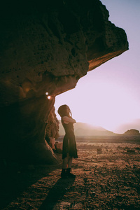 以色列Timna沙漠的美丽年轻女子。 日落时间的岩石。 神秘概念