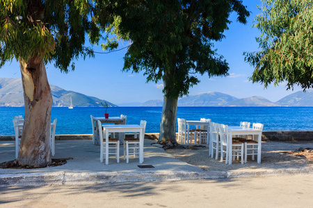 希腊海滨凯法洛尼亚海滩上一家希腊餐馆的蓝色木制桌椅