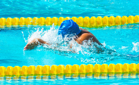 未经辨认的游泳运动员蛙泳在泳池泳道黄线游泳