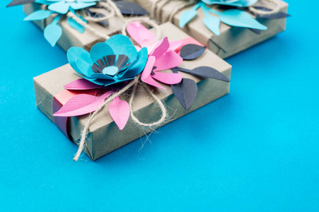 礼品盒包裹工艺纸蓝色背景。 樱花花是由纸折纸制成的。 现在。