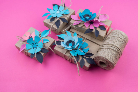 带有粉红色背景丝带的礼品盒。 心是柔软的手工制作的。 最喜欢的爱好包装。用纸做的花。
