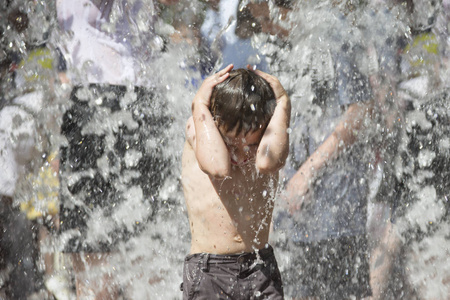 水下喷射的小男孩。 孩子在喷泉里洗澡。 雨中的人在喷泉里洗澡