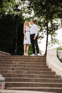 美丽的可爱站在楼梯上互相拥抱。男人和女人走在公园里。洛维斯托里