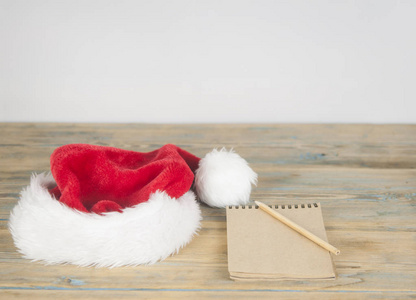 圣诞老人的信，带有圣诞老人帽子，木制背景