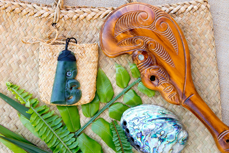 新西兰毛利人主题物玉，布纳木吊坠，帕瓦壳，木帕图，风筝袋，蕨类植物和亚麻叶编织背景