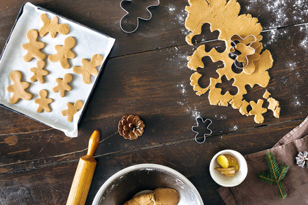 圣诞食品概念。 生面团烹饪姜饼人饼干在圣诞节在木制桌子顶部的视图。 圣诞甜点