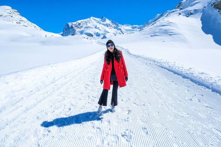 年轻女子游客走在雪山上，物质角峰Zermatt瑞士。