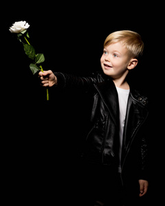 一个小男孩握着一朵花在他的手里