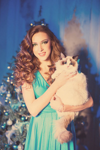 克利斯曼的派对寒假女人和猫。 新年女孩。 内部背景的圣诞树。