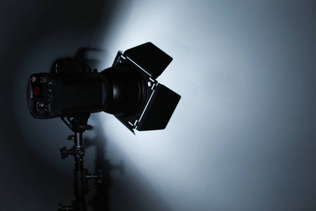 专业摄影棚照明设备在黑暗背景。 文本空间