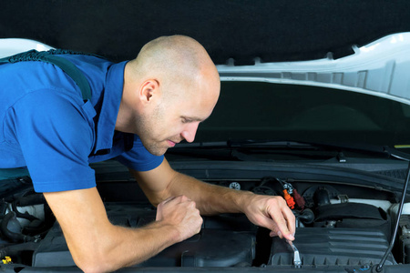 修理汽车发动机马达的年轻汽车服务技术人员。