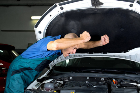修理汽车发动机马达的年轻汽车服务技术人员。