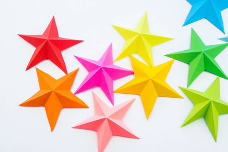 彩虹彩纸做的星星。 节日装饰星空。 白色背景。 最喜欢的爱好。 孩子们的创造力。