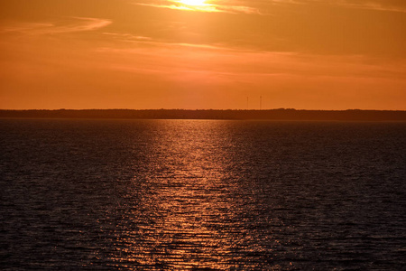 美丽的日落在波罗的海，平静的水和太阳反射在爱沙尼亚