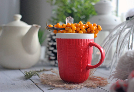 冬天，舒适的背景红茶，带装饰羊毛围巾，手电筒，水壶，黄色浆果的枝条