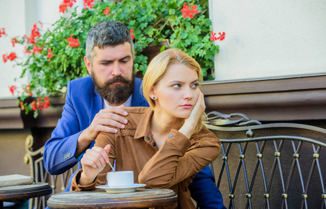 严肃面孔的女人和男人在咖啡馆喝咖啡。关系问题的概念。女孩和胡须的家伙有咖啡咖啡露台背景。在咖啡休息时, 情侣们在爱喝意式浓缩咖啡