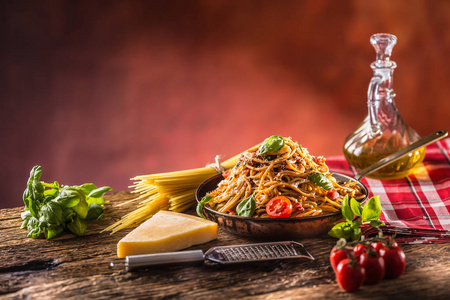 意大利面食意大利面条，番茄酱，橄榄油，罗勒和帕尔马干酪在旧锅。