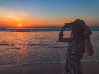 日落日出时间的女孩在海洋上的剪影。