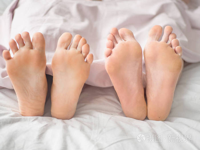 在床上的一对夫妇的脚关闭爱的情侣躺在被窝里