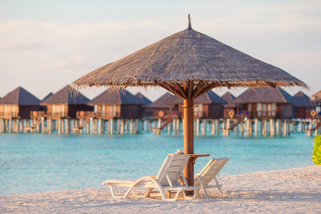马尔代夫美丽的热带海滩上的白色休闲椅
